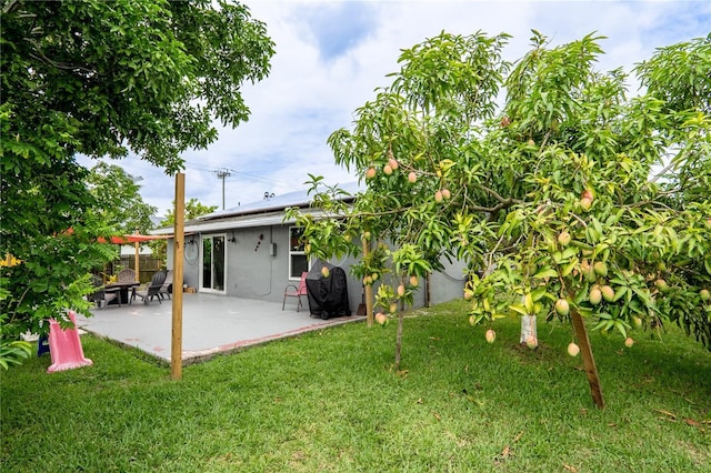1244 Grandview Cir, Royal Palm Beach, FL 33411 - rear view of house with stucco siding, solar panels, and a patio area