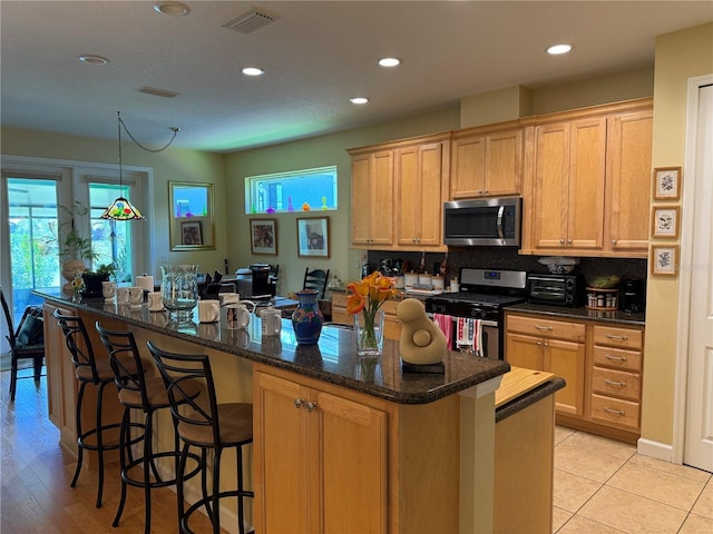8301 Bridgeport Bay Cir, Mount Dora, FL 32757 - kitchen featuring stainless steel appliances, recessed lighting, a center island, a kitchen bar, and backsplash