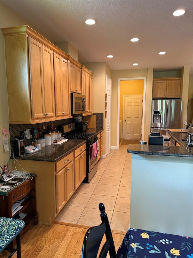 8301 Bridgeport Bay Cir, Mount Dora, FL 32757 - kitchen with appliances with stainless steel finishes, recessed lighting, dark stone countertops, backsplash, and light tile patterned flooring