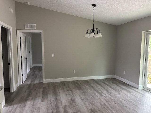 3838 W Baton Ln, Citrus Springs, FL 34433 - unfurnished dining area with wood finished floors, a chandelier, a textured ceiling, and vaulted ceiling