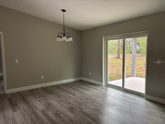 3838 W Baton Ln, Citrus Springs, FL 34433 - empty room with a chandelier, wood finished floors, and a textured ceiling