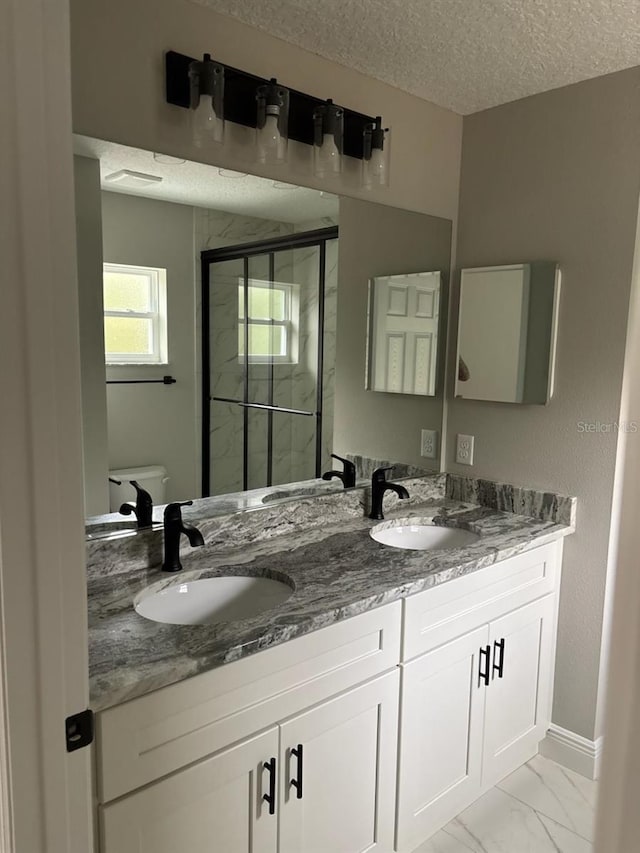 3838 W Baton Ln, Citrus Springs, FL 34433 - bathroom with double vanity, a shower stall, marble finish floors, and a textured ceiling