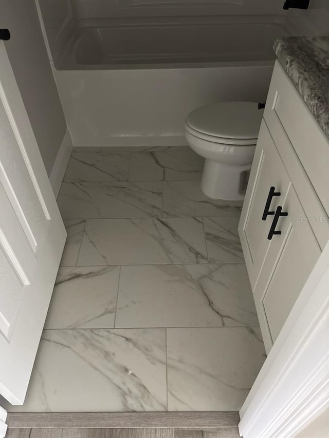3838 W Baton Ln, Citrus Springs, FL 34433 - bathroom featuring marble look tile flooring, vanity, and a bathtub