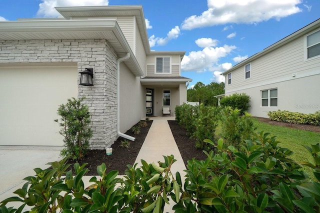 3916 Southern Vista Loop, Saint Cloud, FL 34772 - entrance to property featuring stone siding, an attached garage, and stucco siding