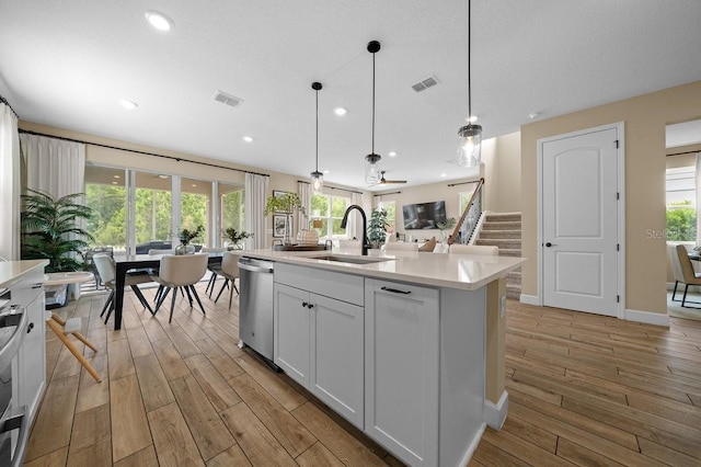 3916 Southern Vista Loop, Saint Cloud, FL 34772 - kitchen with stainless steel dishwasher, light wood-type flooring, light countertops, pendant lighting, and recessed lighting