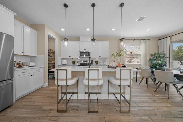 3916 Southern Vista Loop, Saint Cloud, FL 34772 - kitchen featuring appliances with stainless steel finishes, light wood finished floors, backsplash, and recessed lighting