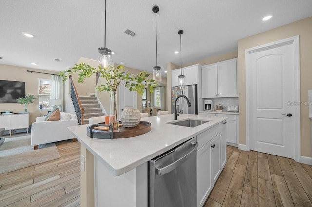 3916 Southern Vista Loop, Saint Cloud, FL 34772 - kitchen featuring appliances with stainless steel finishes, light wood-type flooring, open floor plan, white cabinets, and recessed lighting