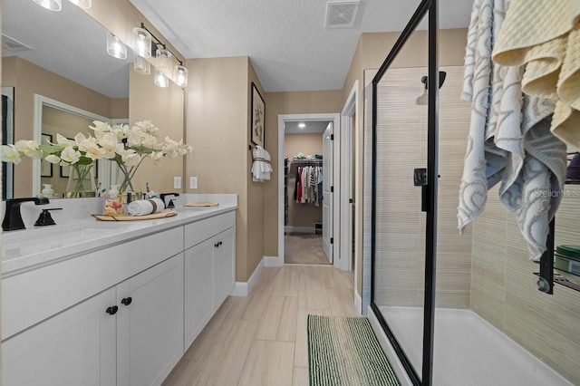 3916 Southern Vista Loop, Saint Cloud, FL 34772 - full bath featuring a stall shower, double vanity, a spacious closet, and a textured ceiling