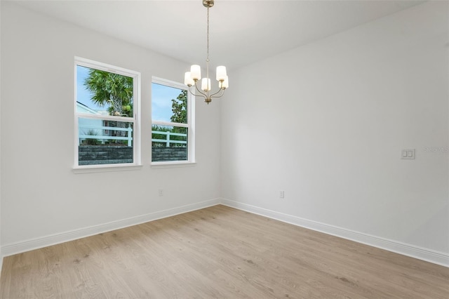 983 Fiesta Key Cir, Lady Lake, FL 32159 - empty room featuring light wood finished floors and a chandelier