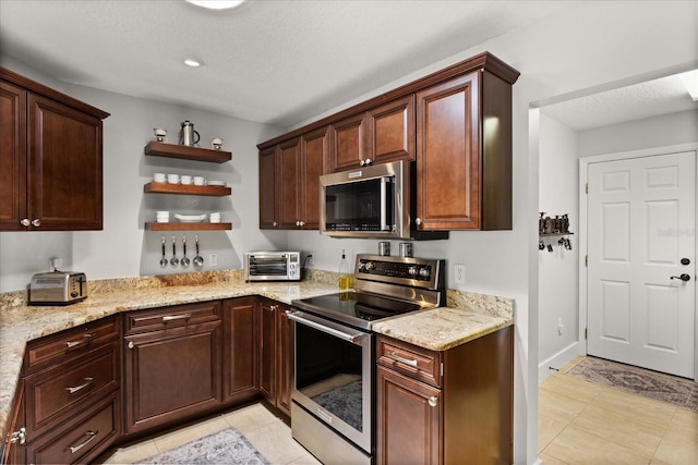 17525 SE 111th Cir, Summerfield, FL 34491 - kitchen featuring appliances with stainless steel finishes, open shelves, light tile patterned floors, light stone countertops, and a textured ceiling
