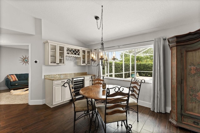 17525 SE 111th Cir, Summerfield, FL 34491 - dining room featuring wine cooler, lofted ceiling, a textured ceiling, dark wood-style flooring, and a dry bar