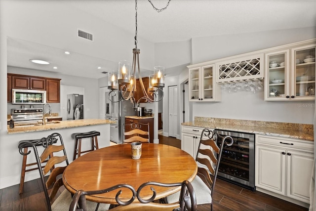 17525 SE 111th Cir, Summerfield, FL 34491 - dining area featuring beverage cooler, lofted ceiling, a bar, a chandelier, and recessed lighting