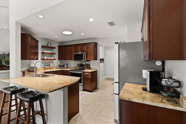 17525 SE 111th Cir, Summerfield, FL 34491 - kitchen with appliances with stainless steel finishes, a peninsula, open shelves, light tile patterned floors, and a textured ceiling