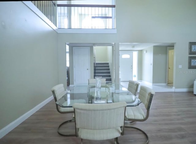 7938 Tumblestone Dr, Orlando, FL 32819 - dining area with stairway, a high ceiling, wood finished floors, and healthy amount of natural light