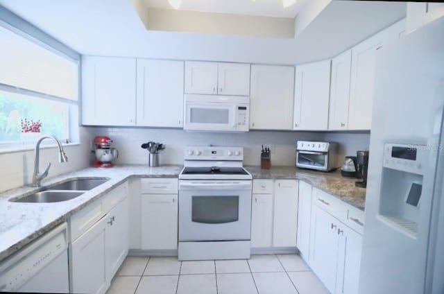 7938 Tumblestone Dr, Orlando, FL 32819 - kitchen featuring white appliances, white cabinetry, light tile patterned flooring, and light stone counters