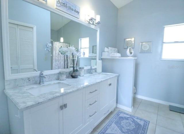 7938 Tumblestone Dr, Orlando, FL 32819 - full bath with double vanity, tile patterned floors, a shower with curtain, lofted ceiling, and a closet