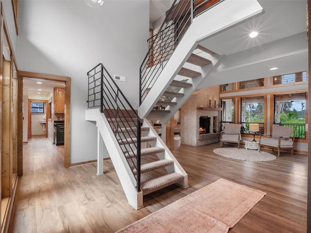 1978 Brantley Cir, Clermont, FL 34711 - stairs with a high ceiling, plenty of natural light, a fireplace, wood finished floors, and recessed lighting