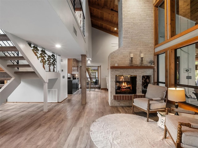 1978 Brantley Cir, Clermont, FL 34711 - living room featuring high vaulted ceiling, wood finished floors, a fireplace, stairs, and healthy amount of natural light