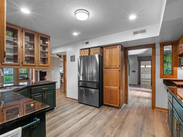1978 Brantley Cir, Clermont, FL 34711 - kitchen with freestanding refrigerator, light wood finished floors, a textured ceiling, glass insert cabinets, and recessed lighting