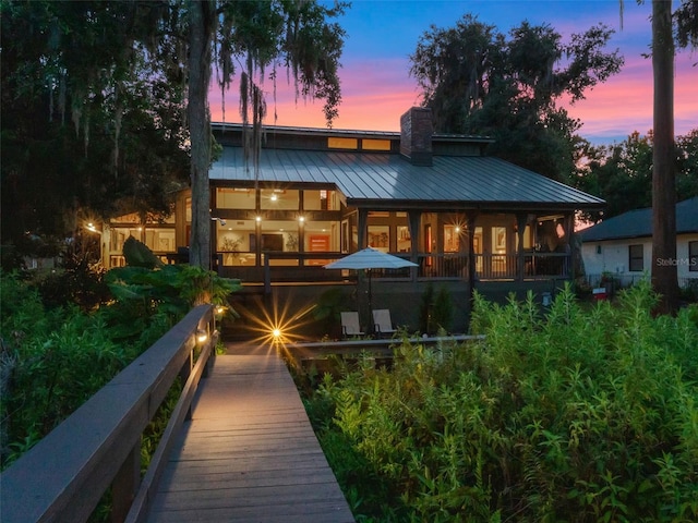 1978 Brantley Cir, Clermont, FL 34711 - back of house featuring a metal roof, a chimney, and a standing seam roof