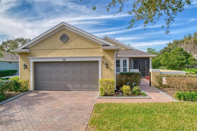 370 Salt Marsh Ln, Groveland, FL 34736 - ranch-style home with stucco siding, decorative driveway, a garage, and a gate