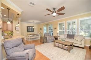 370 Salt Marsh Ln, Groveland, FL 34736 - living room featuring ornamental molding, a ceiling fan, wood finished floors, and arched walkways