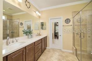 370 Salt Marsh Ln, Groveland, FL 34736 - full bathroom with crown molding, double vanity, and a shower stall