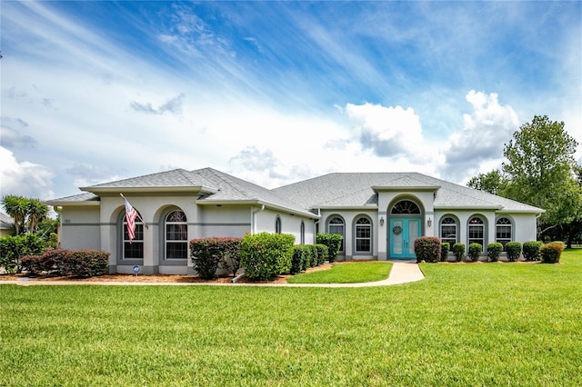 7811 Laurel View Dr, Mount Dora, FL 32757 - view of front of home with a front yard, stucco siding, and roof with shingles