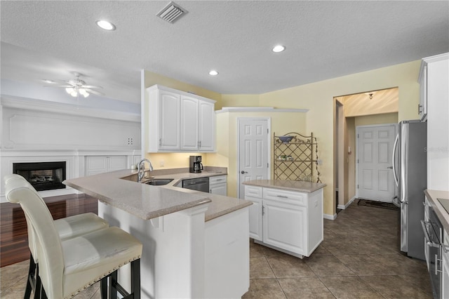 7811 Laurel View Dr, Mount Dora, FL 32757 - kitchen featuring stainless steel appliances, ceiling fan, a peninsula, a center island, and white cabinets