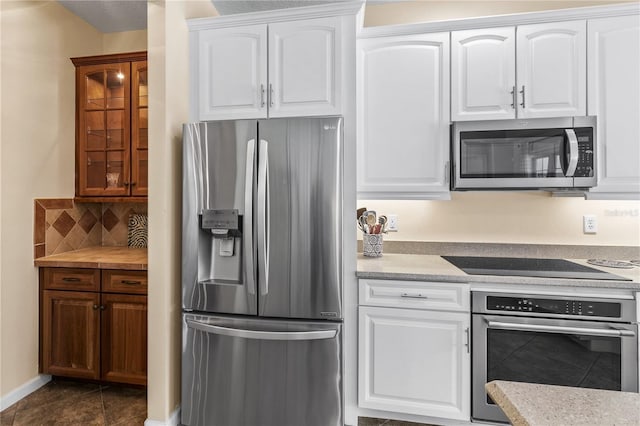 7811 Laurel View Dr, Mount Dora, FL 32757 - kitchen with stainless steel appliances, decorative backsplash, white cabinetry, and dark tile patterned floors