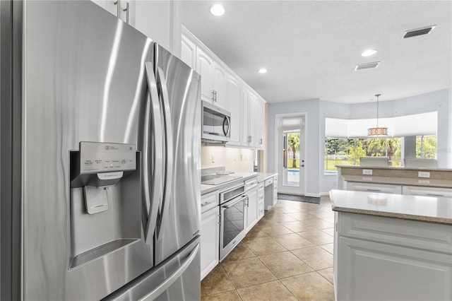 7811 Laurel View Dr, Mount Dora, FL 32757 - kitchen featuring appliances with stainless steel finishes, white cabinetry, light tile patterned floors, pendant lighting, and recessed lighting