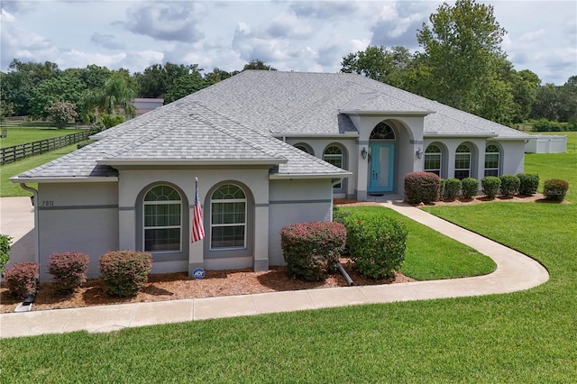 7811 Laurel View Dr, Mount Dora, FL 32757 - view of front of house featuring a shingled roof, a front yard, and stucco siding