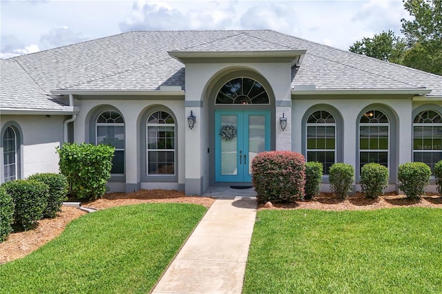 7811 Laurel View Dr, Mount Dora, FL 32757 - view of exterior entry with a yard, a shingled roof, and stucco siding