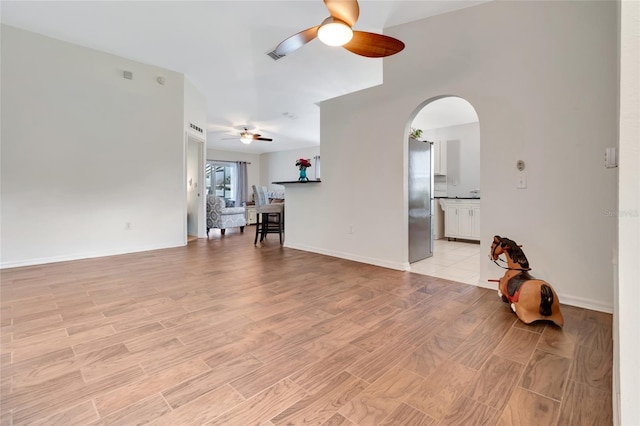 2305 Foxtree Rd, Tavares, FL 32778 - unfurnished living room featuring ceiling fan, arched walkways, and light wood-style flooring