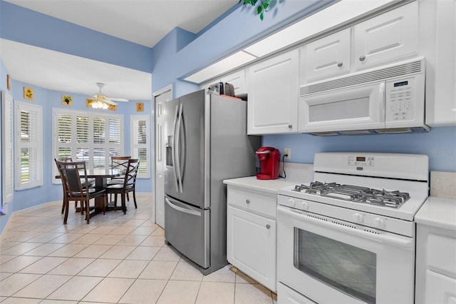 6307 Berkshire Pass, Leesburg, FL 34748 - kitchen with white appliances, light countertops, light tile patterned floors, and white cabinets