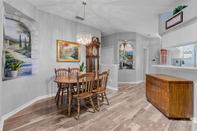 6307 Berkshire Pass, Leesburg, FL 34748 - dining space with light wood-style flooring, a chandelier, and vaulted ceiling