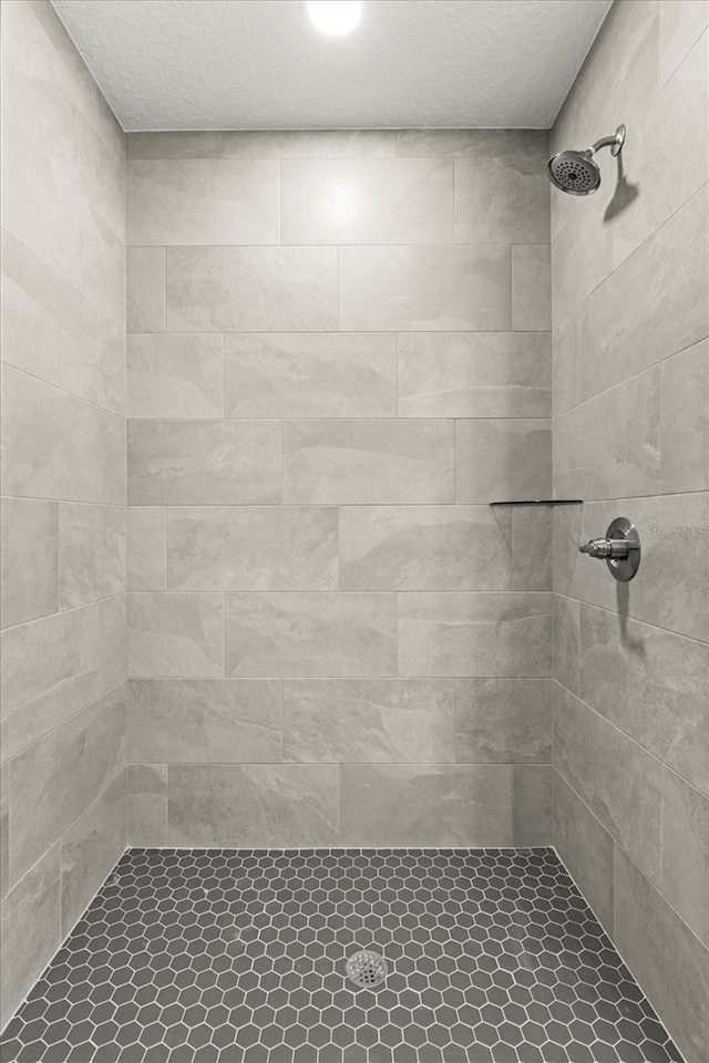 671 E Toledo Dr, Citrus Springs, FL 34434 - bathroom featuring a tile shower and a textured ceiling