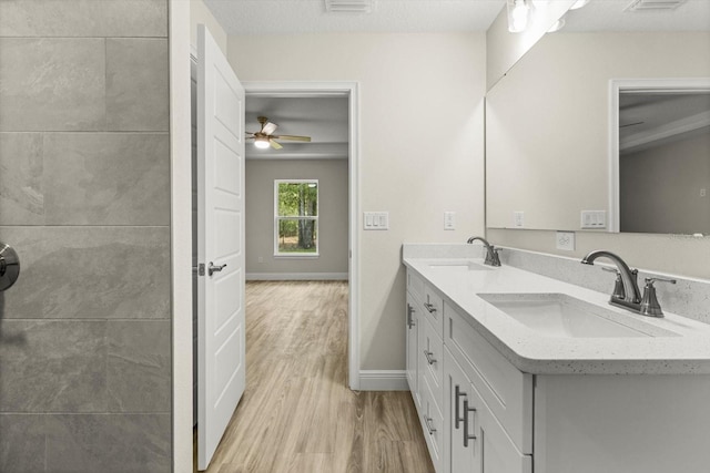 671 E Toledo Dr, Citrus Springs, FL 34434 - bathroom featuring wood finished floors, double vanity, and a ceiling fan