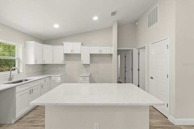 671 E Toledo Dr, Citrus Springs, FL 34434 - kitchen featuring a center island, white cabinetry, light wood finished floors, light stone countertops, and recessed lighting