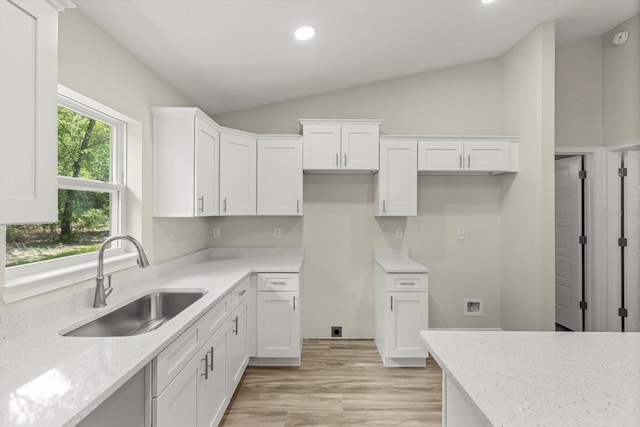 671 E Toledo Dr, Citrus Springs, FL 34434 - kitchen with vaulted ceiling, light stone counters, white cabinets, recessed lighting, and light wood-type flooring