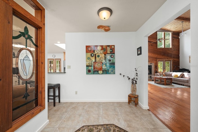 7201 SW 97th Ln, Gainesville, FL 32608 - foyer with ceiling fan, wood walls, tile patterned floors, a fireplace, and wood ceiling