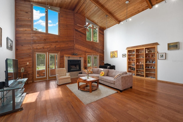 7201 SW 97th Ln, Gainesville, FL 32608 - living room featuring high vaulted ceiling, a ceiling fan, wood-type flooring, a fireplace, and a wooden ceiling with exposed beams