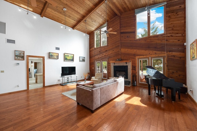 7201 SW 97th Ln, Gainesville, FL 32608 - living area with high vaulted ceiling, a fireplace with raised hearth, a ceiling fan, a wooden ceiling with exposed beams, and hardwood / wood-style floors