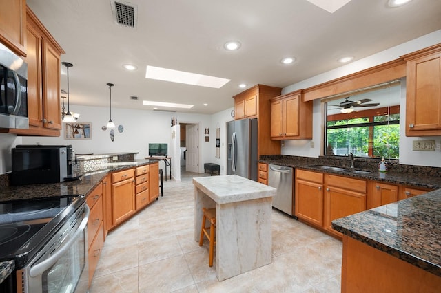 7201 SW 97th Ln, Gainesville, FL 32608 - kitchen with appliances with stainless steel finishes, a skylight, decorative light fixtures, recessed lighting, and dark stone counters