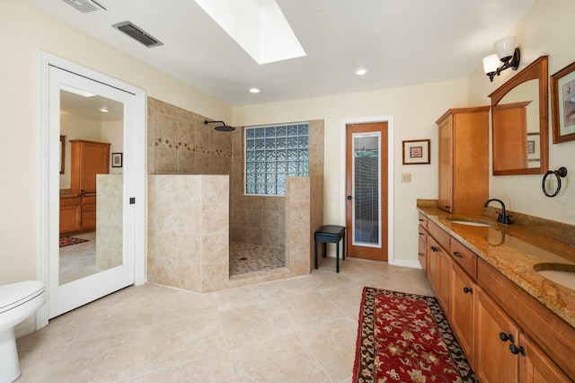 7201 SW 97th Ln, Gainesville, FL 32608 - bathroom featuring a skylight, a walk in shower, double vanity, recessed lighting, and tile patterned flooring