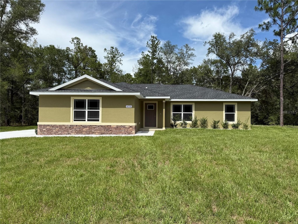 675 E Toledo Dr, Citrus Springs, FL 34434 - view of front facade with stucco siding, stone siding, and a front lawn