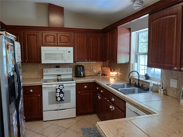 309 N Westwood St, Bushnell, FL 33513 - kitchen with white appliances, decorative backsplash, vaulted ceiling, tile countertops, and light tile patterned floors