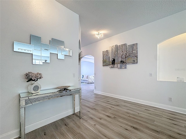 2421 Cimmaron Ash Way, Apopka, FL 32703 - hallway featuring arched walkways, wood finished floors, and a textured ceiling