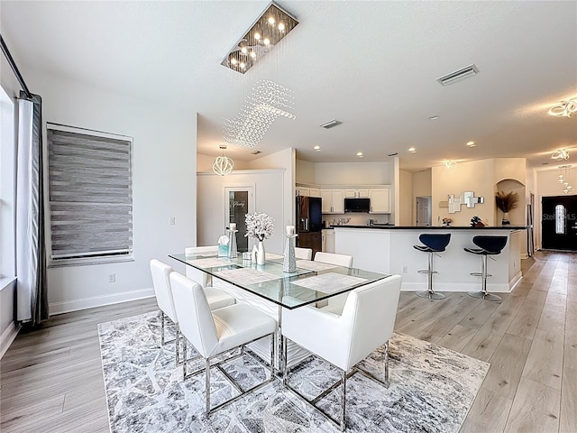 2421 Cimmaron Ash Way, Apopka, FL 32703 - dining space featuring light wood-style flooring, arched walkways, and recessed lighting