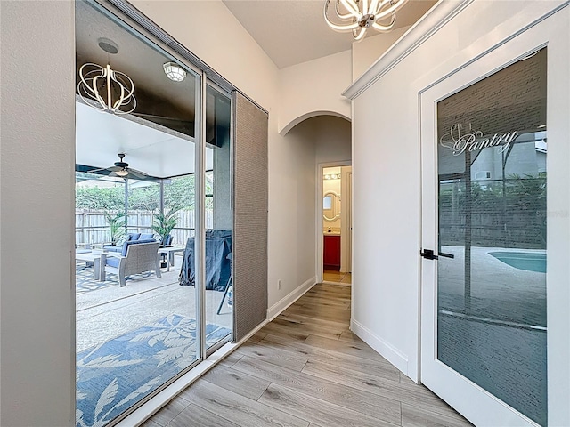 2421 Cimmaron Ash Way, Apopka, FL 32703 - entryway featuring arched walkways, a chandelier, light wood-style flooring, and ceiling fan